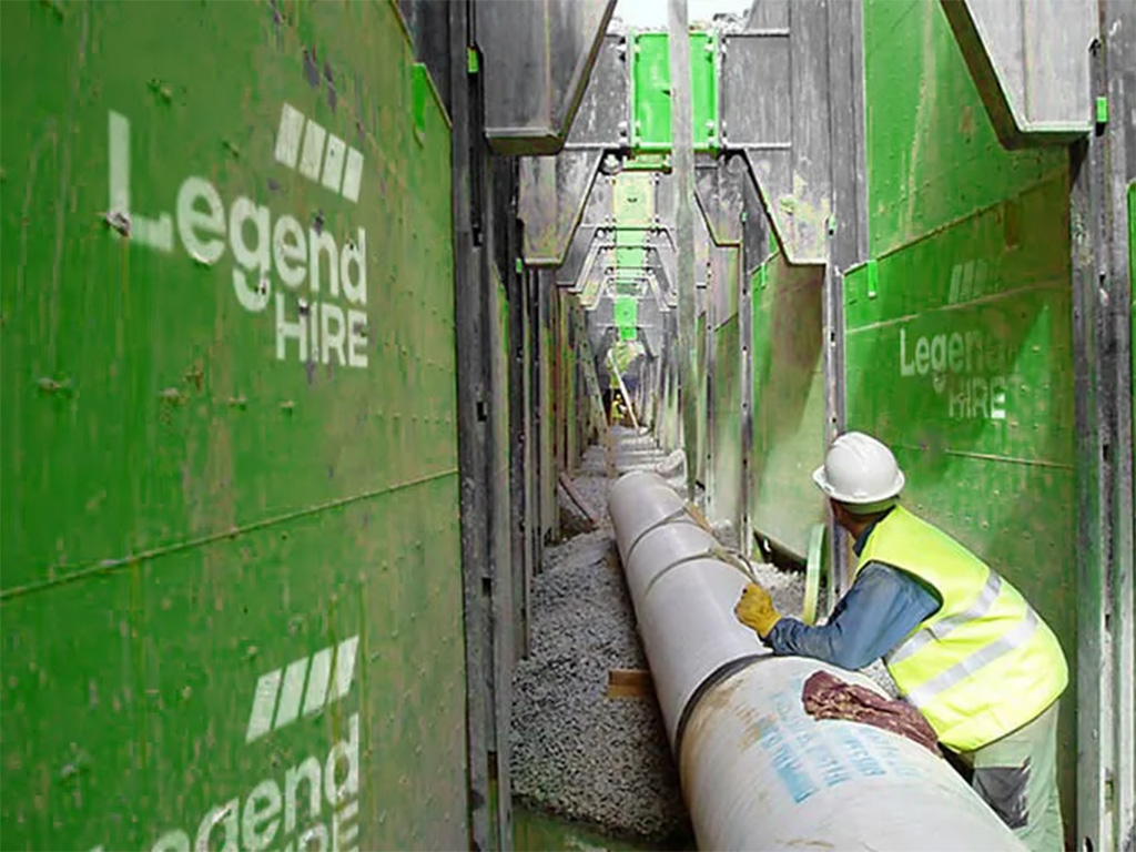 Legend Hire green trench shoring panels supporting a pipe installation on an Australian civil site
