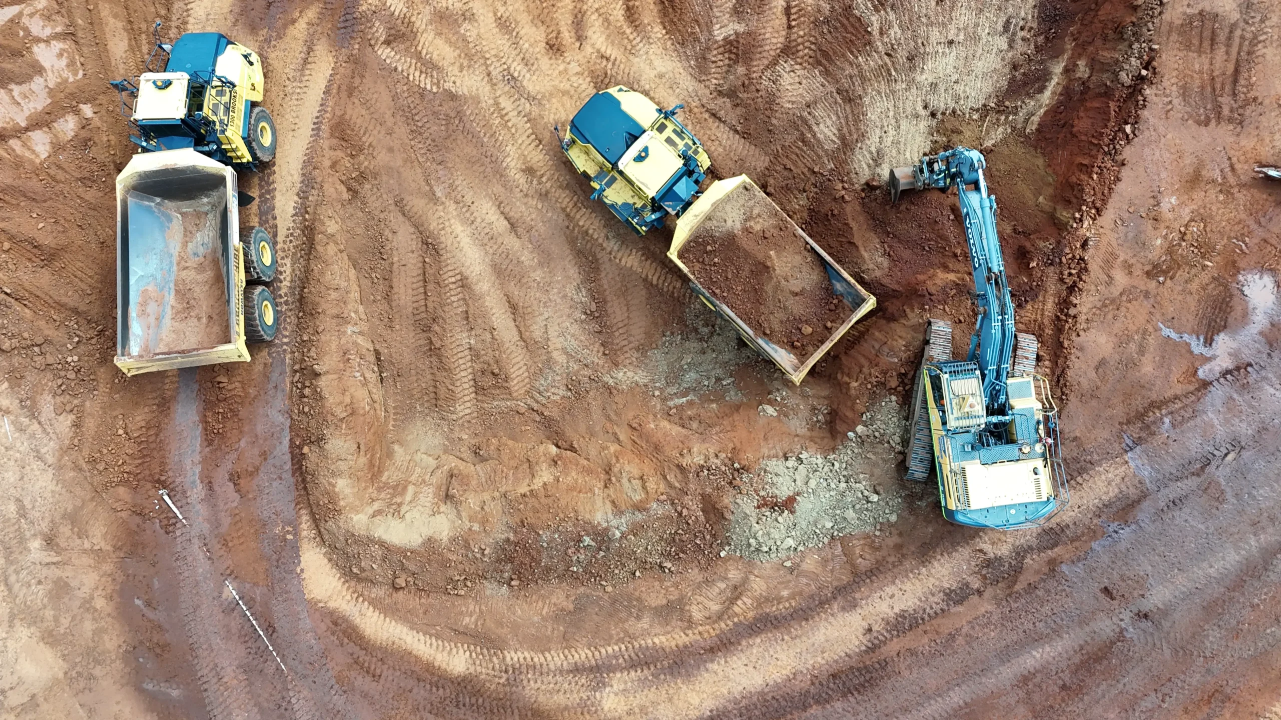 Aerial view of excavator loading a dump truck during bulk earthworks